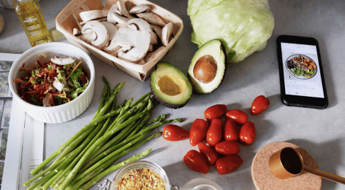 picture of fruits and vegetables on a clean counter with a phone and a recipe is visible on the screen